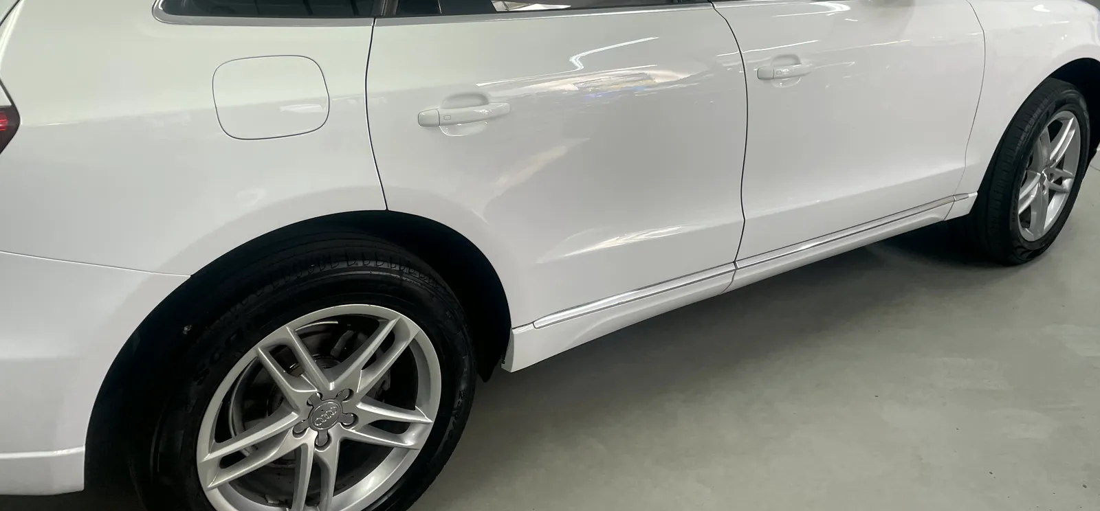 Fiancata di un SUV bianco appena lavato a mano, carrozzeria lucida e cerchi puliti